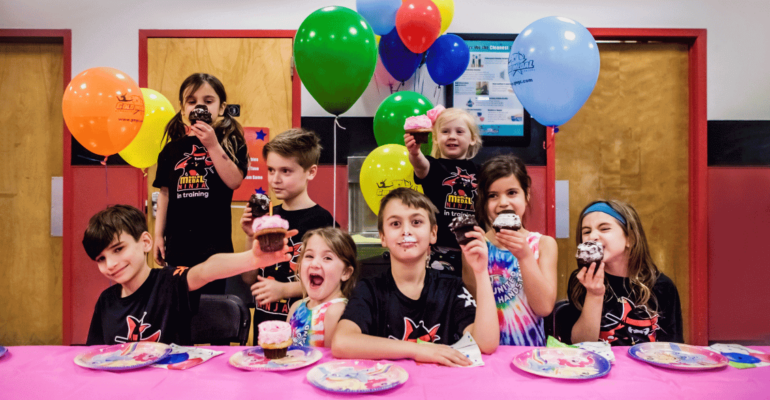 Kids at a Gold Medal Birthday Party eating cupcakes