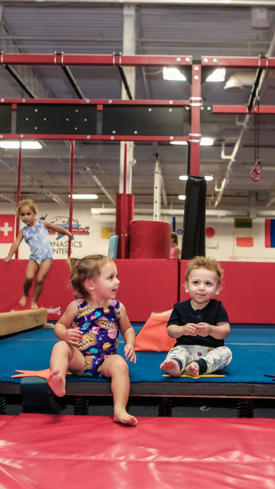 Toddlers on the balance beam in a preschool gymnastics class at Gold Medal