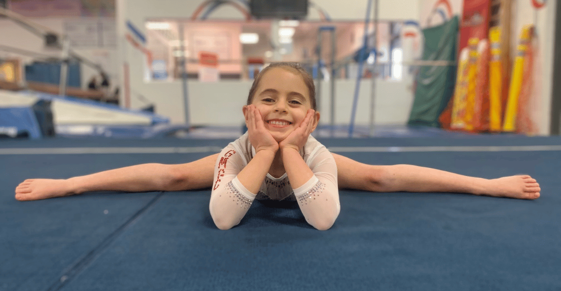 competitive gold medal gymnastics team gymnast doing the splits